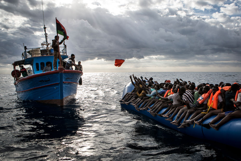 From Mathieu Willcock’s prize-winning ‘Mediterranean Migration’ news story. Libyan fishermen throw a life jacket to a boat of refugees. ©Mathieu Willcocks