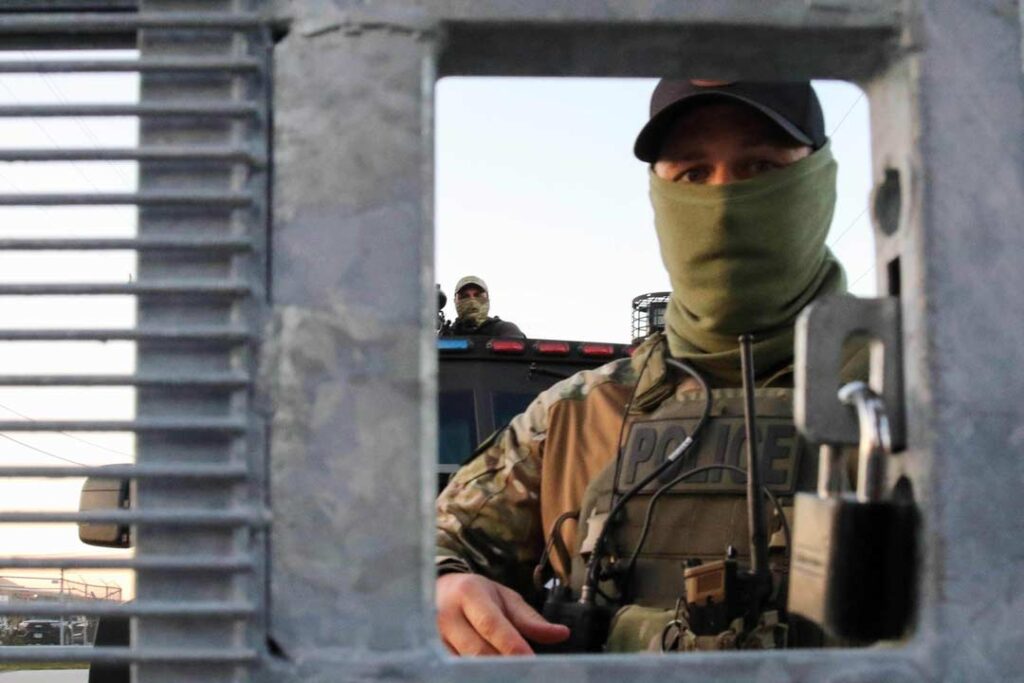 Broadview’s Stand #2
Federal agents unlock the gate each morning to remove the posters put up on the front of the security fencing surrounding the front entrance of the ICE detention facility on Beach Street in Broadview, IL, USA. Since the start of September, protesters have returned to this facility to attempt to block operations tied to enforcement sweeps.
Alexandra Buxbaum © All rights reserved.