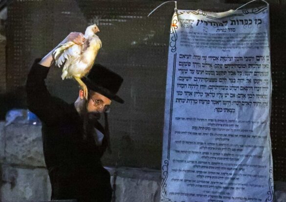 A man performs the ritual at sunrise. The prayer he recites is posted on the wall beside him. Yoram Biberman © All rights reserved.